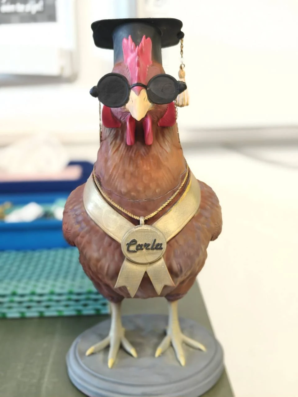 Portret van de afgewerkte Carla met bruine veren, rode kam en goudkleurige medaille